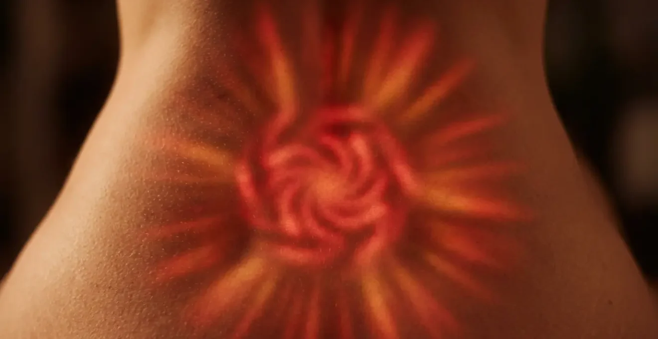 Close-up of lower back area with glowing red energy center at the base of spine, showing energy flow patterns